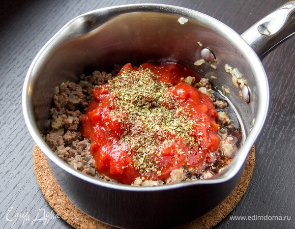 Добавить томаты в собственном соку (вместе с соком). Приправить смесью перцев, солью и сушеными травами.