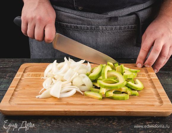 Нарежьте лук полукольцами, авокадо очистите и нарежьте ломтиками.