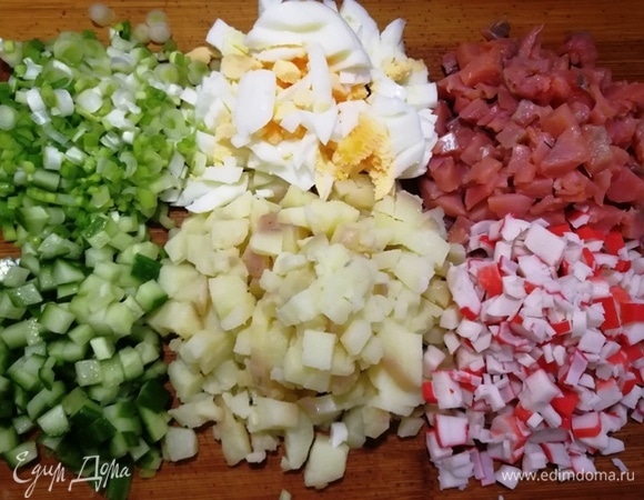 Для салата возьмем отварной картофель среднего размера, яйца некрупные (С1), крабовые палочки, огурчик средний (без сердцевины), белую часть зеленого лука, слабосоленый лосось. Все ингредиенты нарежем одинаковым кубиком.