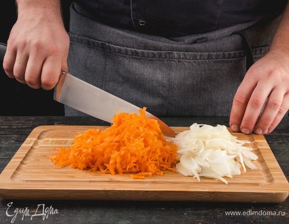 Очистите луковицу и нарежьте ее средними кубиками. Морковь натрите на крупной терке. Обжарьте овощи на сковороде с растительным маслом, постоянно помешивая.