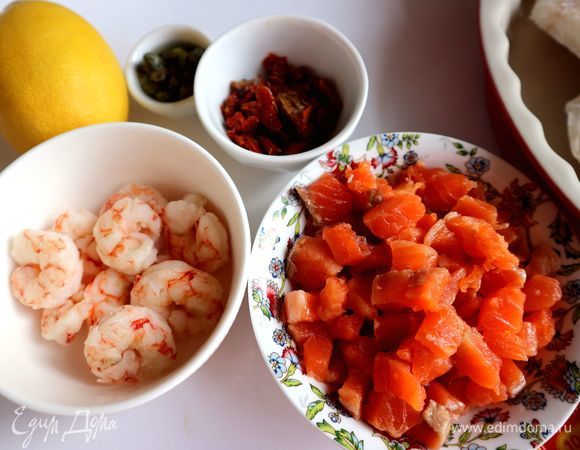 Креветки (здесь крупные дикие аргентинские креветки варено-мороженые, уже очищенные) поместить на несколько минут в кипящую подсоленную воду. После повторного закипания воды варить креветки минуты 3, не больше. Воду слить, дать остыть, разрезать каждую креветку вдоль на две части. Убрать в холодильник до использования. Красную рыбу нарезать мелкими кубиками.