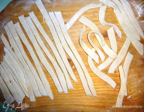 Тесто нарезать тонкими длинными полосками. Оставить на доске подсушиться, пока будет вариться бульон.