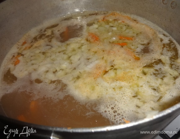 В бульон положить картофель, морковь, лук. Продолжить варить почти до готовности картофеля.