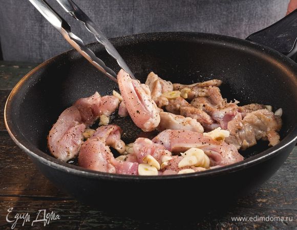 Нарежьте филе тонкими полосками, чеснок раздавите или мелко нарежьте. Выложите мясо с чесноком на разогретую сковороду, посолите по вкусу, обжаривайте 5–7 минут.