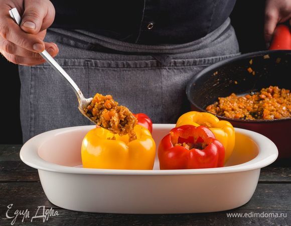 Начините смесью овощей и булгура перцы, выложите их в небольшую форму, на дно которой налейте примерно 1 см воды. Духовку переключите на режим подогрева «верх/низ» и поставьте в нее перцы на 10 минут.