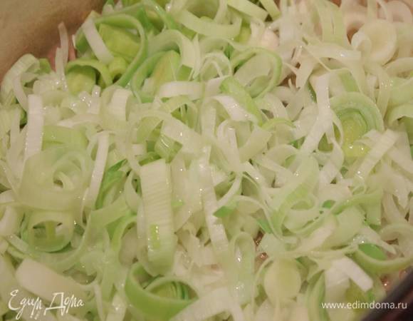 Чеснок почистить, нарезать пластинками, добавить к луку и томить все, периодически помешивая, пока лук не станет мягким и нежным.