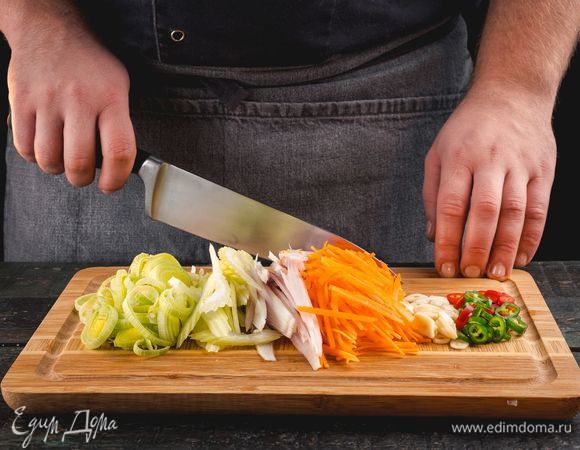 Нарежьте лук-порей, лук-шалот, сельдерей, морковь, перец чили и чеснок.