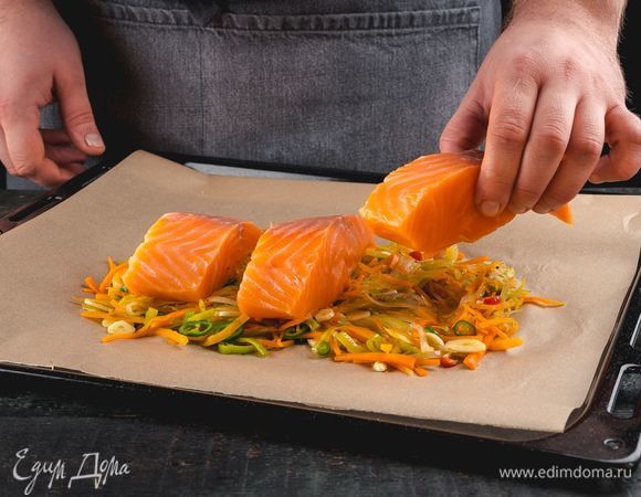 В небольшой глубокий противень выложите овощи со сковороды, сверху — филе лосося. Добавьте соль и перец по вкусу.