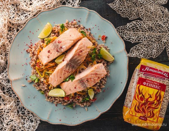 Достаньте противень из духовки и оставьте на 5 минут. Выложите рис на блюдо. Сверху — рыбу и овощную смесь. Ароматное праздничное блюдо готово!