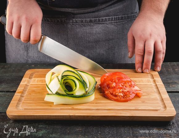 Нарежьте цукини и помидоры.