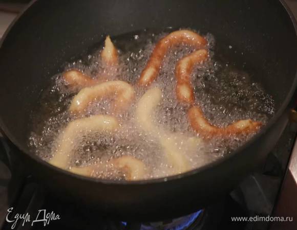 Тесто выложить в кондитерский мешок, выдавливать из него в кипящее масло фигурки разной формы и обжаривать со всех сторон до золотистого цвета, затем выложить на бумажное полотенце, чтобы избавиться от лишнего масла.