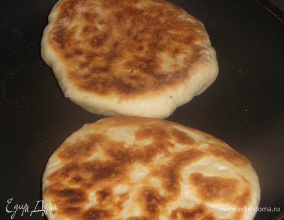 Обжарить до румяной корочки с двух сторон под крышкой на умеренном огне. Готовность определите по подъему хачапури, когда будете жарить со второй стороны.