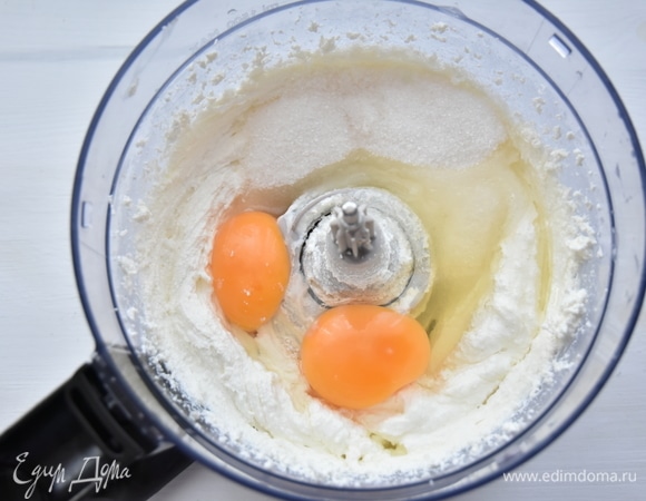 Для творожной начинки протереть творог через сито или взбить его с помощью блендера. Добавить яйца, ванилин и сахар. Смешать до однородного состояния.