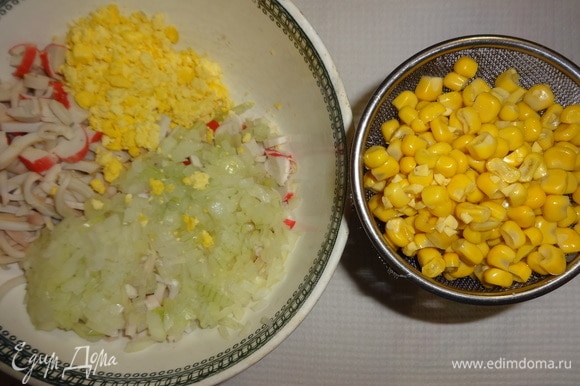 Слить жидкость с необходимого количества кукурузы. Одну чайную ложку кукурузы отложить. Подготовленные для салата продукты положить в чашку (кроме белков).