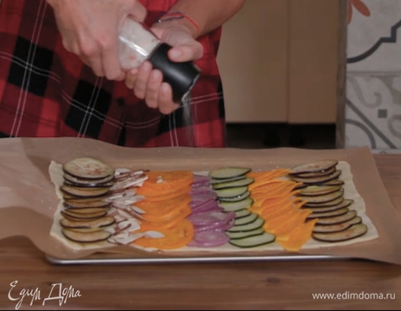 На тесто рядами внахлест выложить овощи и грибы, посолить, поперчить, полить половиной оливкового масла, посыпать оливками, каперсами и половиной листьев тимьяна, сверху разложить вяленые помидоры и анчоусы.