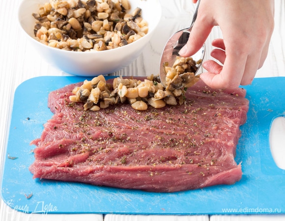 Начинку немного измельчить ножом. На один край пласта вырезки щедро выложить начинку и свернуть в плотный рулет.