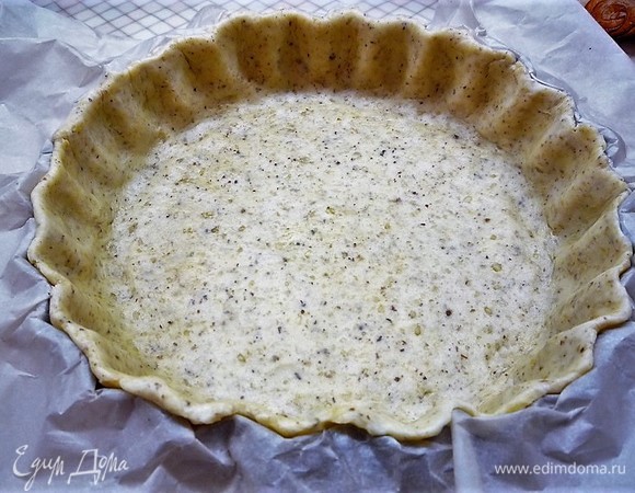 Форма у меня размером 26 см. Раскатываем тесто на пергаменте в пласт толщиной 2–3 мм. Перекладываем в форму для выпечки, формируем бортики, срезая скалкой лишнее тесто.
