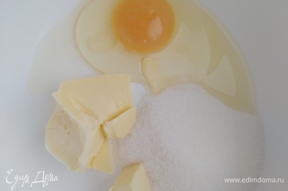 В миске соединить яйцо, сахар и размягченное сливочное масло. Взбить миксером до пышности и однородности.