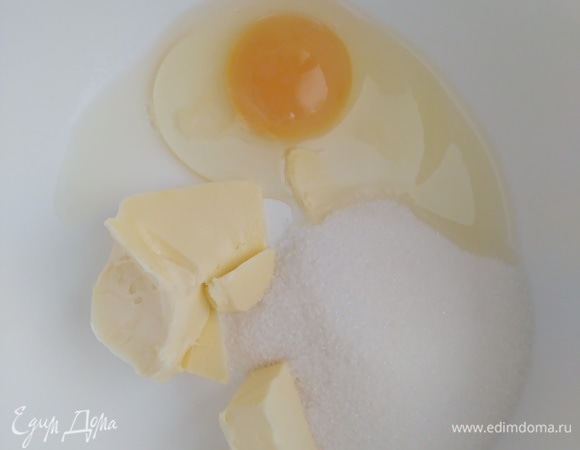 В миске соединить яйцо, сахар и размягченное сливочное масло. Взбить миксером до пышности и однородности.