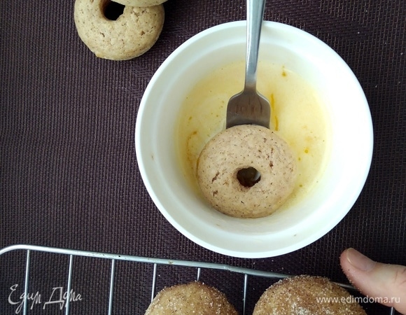 Обмакнуть каждый пончик в масло, поместить в пакет с сахаром и встряхнуть, чтобы равномерно распределить обсыпку.