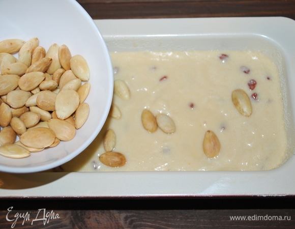 Форму для кекса смазать маслом (можно посыпать немного манной крупой), выложить тесто, сверху посыпать миндалем. Запекать при 170°C примерно 35 минут до готовности.