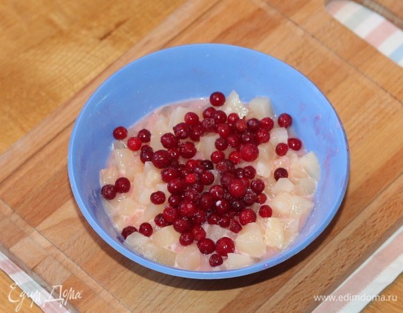 Выкладываем кусочки ананаса в белковую смесь и перемешиваем. Затем кладем горсть брусники и аккуратно еще раз перемешиваем. Выкладываем фрукты в сито.