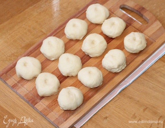 Сформируем булочки. Делим тесто на 12 частей, скатываем в шарики. Пока формируете булочки, держите тесто и заготовки для булочек под пленкой или накройте прозрачным пищевым пакетом. Это для того, чтобы не обветрилось тесто.