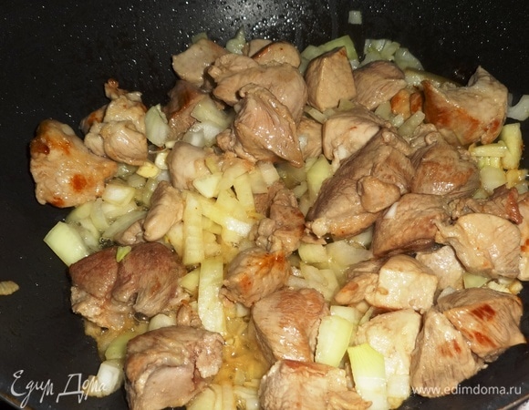 Добавить лук к мясу, перемешать и продолжать обжаривать.