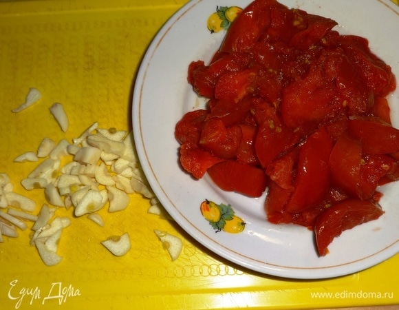 Чеснок почистить и мелко нарезать. Помидоры вымыть, нарезать дольками. Я брала замороженные помидоры, предварительно порезанные.