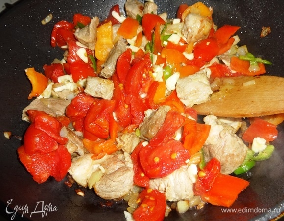 Помидоры и чеснок добавить в сковороду, перемешать.