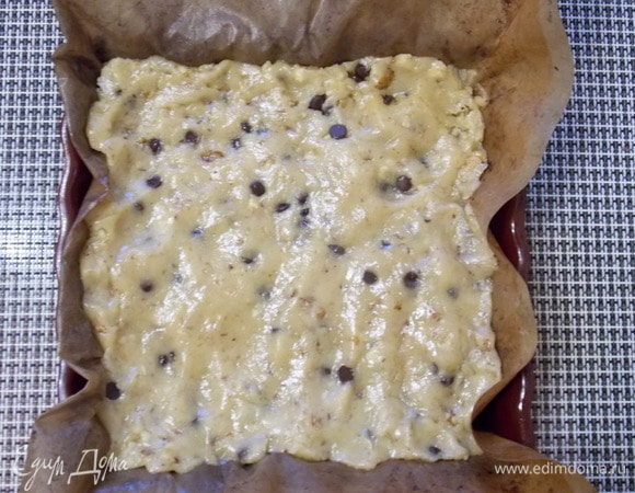 Застелить форму 24х24 см бумагой для выпечки и выложить тесто. Разровнять верх сырыми руками.