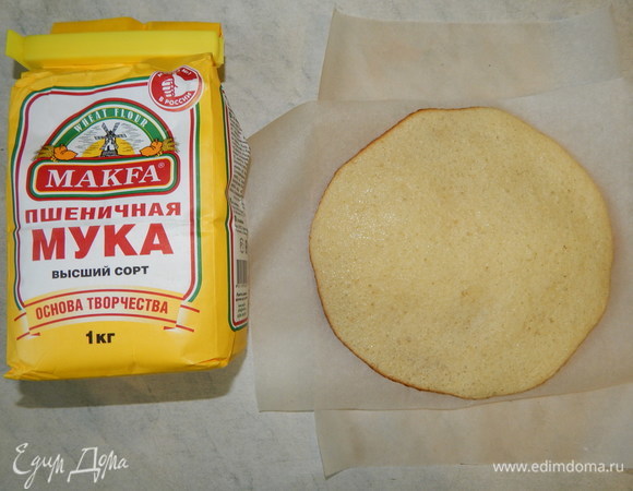 Аккуратно снимаем горячие коржи и перекладываем их бумагой для выпечки.