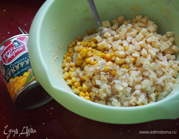 Кладем в фарш сладкую кукурузу ТМ «Фрау Марта», кукурузную муку, сметану, обжаренный лук и нарезанный кубиком твердый сыр. Хорошо смешиваем все ингредиенты для будущих маффинов.