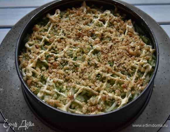 Поверх огурцов распределить горсть рубленых грецких орехов.