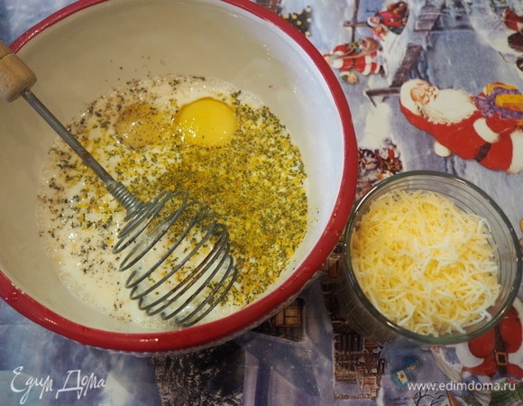 Для заливки сыр трем на мелкой терке. В миске смешиваем молоко, яйца, специи и половину сыра.