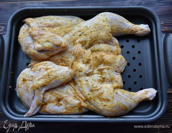 Выложить птицу на решетку. Под низ поставить противень, куда будет стекать лишний жир. Запекать в духовке, разогретой до 200°C, до поджаристой корочки.