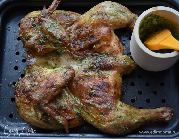 Готового цыпленка достать из духовки и смазать чесночным соусом. Подавать сразу. Оставшийся соус перелить в миску и подать к мясу.