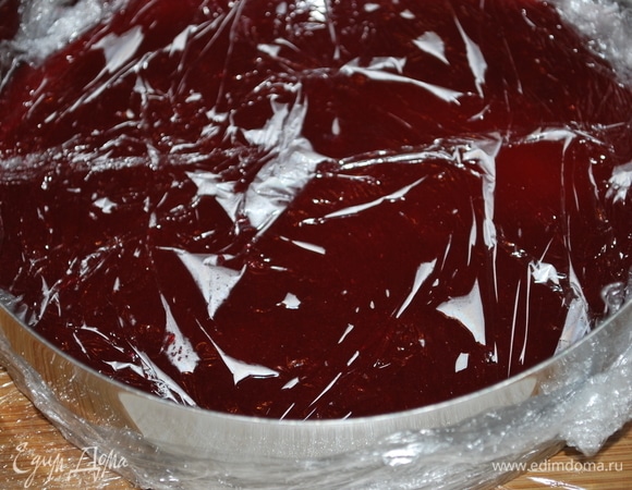 Кольцо диаметром 18 см затянуть пленкой, поставить на ровную поверхность (я поставила на разделочную доску). Налить горячее пюре в кольцо, разровнять и закрыть пленкой, убрать в холодильник. Малиновый слой хорошо зажелируется и будет стабильным уже через несколько часов. Бисквит и малиновый слой я приготовила накануне за 2 дня.