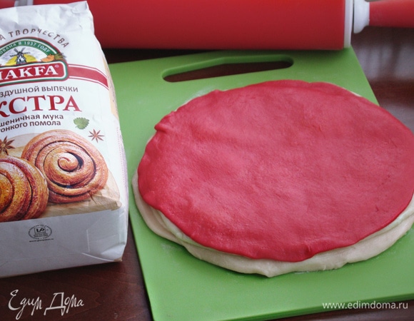 Таким образом сложить стопочкой все раскатанные и смазанные маслом лепешки. Верхний слой — окрашенный. Теперь эту стопку из лепешек раскатать в еще большую по диаметру лепешку, следя за тем, чтобы окрашенный слой был равномерно распределен по всей поверхности. Лепешку разрезать на одинаковые треугольники. У меня получилось 12 штук.