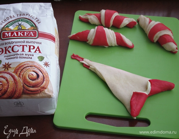 Каждый треугольник слегка надрезать со стороны широкого края и свернуть рулетиком.