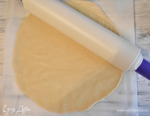 Готовое тесто выкладываю на столешницу, посыпанную мукой, и раскатываю круг, равный диаметру сковороды.