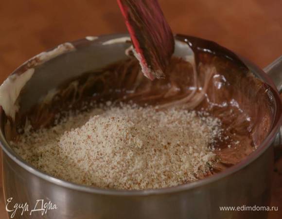 Миндаль измельчить в муку, всыпать в шоколадно-желтковую массу и вымешать лопаткой.