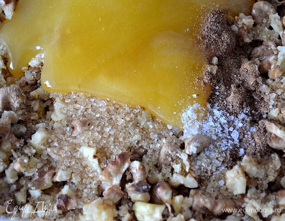 Надо обжарить на раскаленной сковороде грецкие орехи и измельчить их. Я делаю это в полотенце: выкладываю на него орехи, накрываю и прокатываю скалкой. В орехи кладем мед, корицу, чуть-чуть соли и сахара по вкусу.