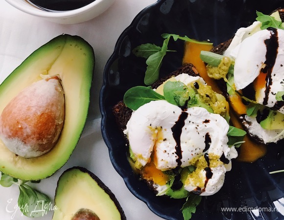 Нарезать тонкими полосками спелое авокадо и выложить на тосты. Поверх авокадо выложить немного руколы.