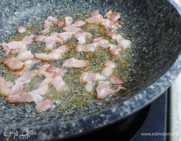 В той же сковороде, где жарились голени, обжарить три полоски сырокопченого бекона, нарезанного небольшими кусочками.