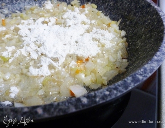 Всыпать муку и хорошо размешать, пока она не объединится с жиром. Медленно влить куриный бульон, помешивая, пока не получится густой соус.