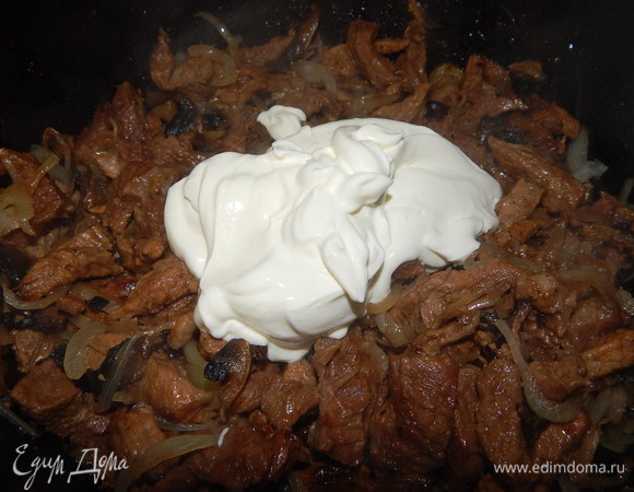 К мясу выложить сметану, перемешать, накрыть крышкой и тушить еще 30 минут.