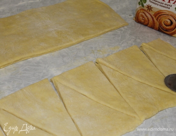 Разрежьте пласт на полосы шириной 15 см и раскроите их на треугольники размером 10х15 см.