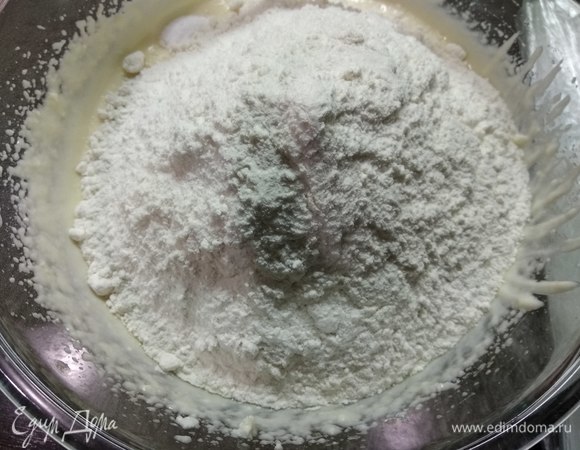 Добавляем просеянную муку, кокосовую стружку и разрыхлитель.