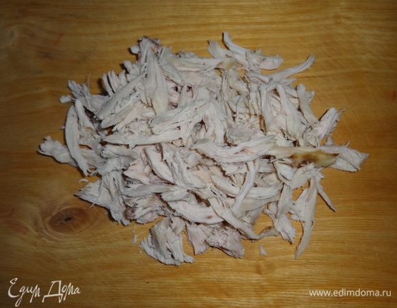 Куриное филе отварить в подсоленной воде до готовности, остудить в бульоне. Остуженное филе разделить руками на волокна.